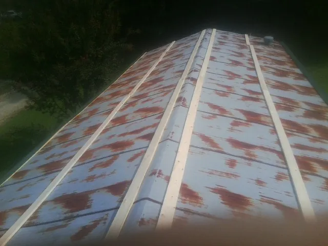 Rusted metal roof panels with new wood purlins before replacement — Storm Damage Roof Repair in Lucile by Roofing Brothers