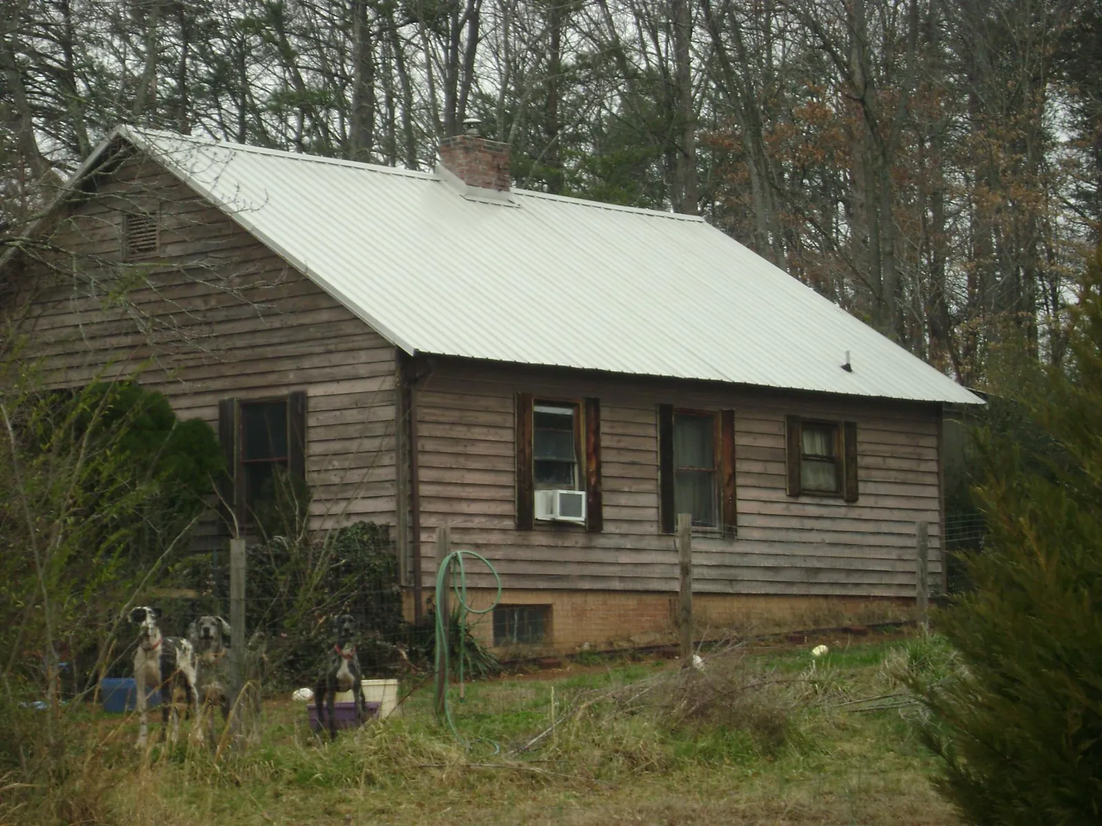 White metal roof on an old wood sided farmhouse, from a Metal Roof Installation job in Lucile